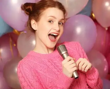 快乐唱歌的女孩.麦克风在背景的美丽女人照片