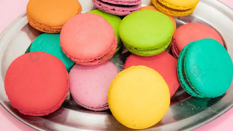 粉红色背景中的甜点蛋糕马卡龙或马卡龙