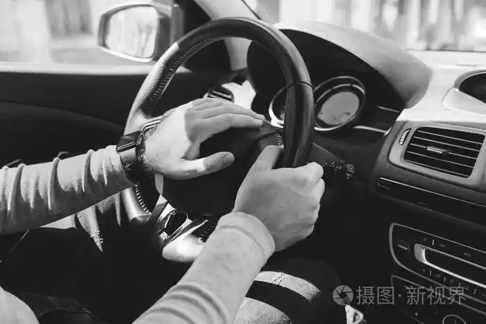 一个男人开车时手拿方向盘的特写镜头