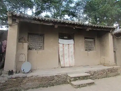 图为小奋家修缮前破旧的泥土房