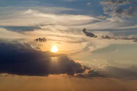 在晴朗的天空上,由明亮的橙色黄色太阳照亮的深蓝色云彩的美丽景色.