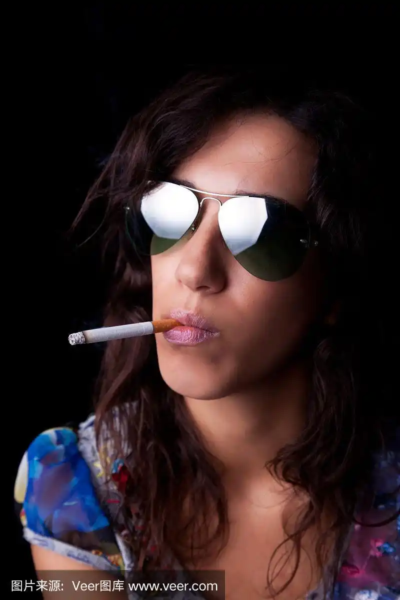 年轻性感的黑发女人,抽烟,戴着墨镜
