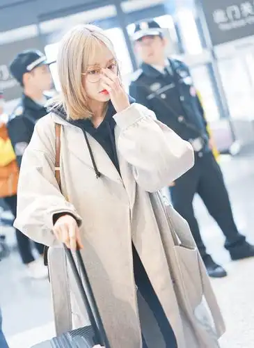 冯薪朵身穿浅色毛呢大衣现身机场 撩发行走青春活力十足