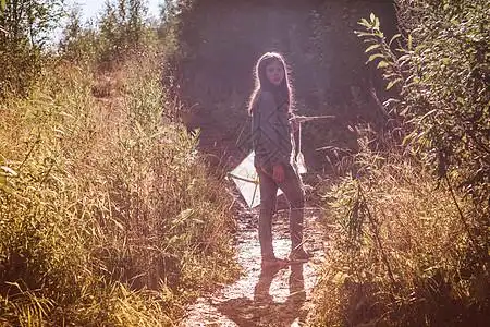 宇智波带土少女带着风筝在乡间小道上回头看背景