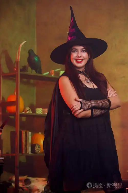 女巫的肖像在黑色礼服和帽子在魔术房间照片-正版商用图片0tdky1-摄图