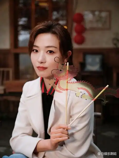 万茜龙年时尚秀大衣搭配牛仔裤手持龙年糖画送祝福