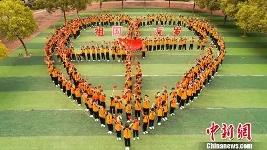 航拍泰和县实验小学学生开展大课间活动,列队摆出巨型心形图案,寓意