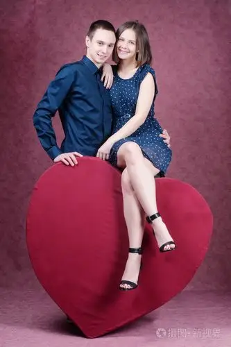 美丽对年轻情侣拥抱在一颗巨大的心