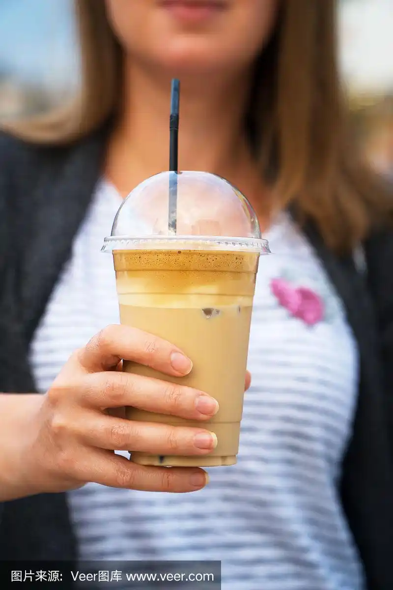 女人的手拿着冰冰咖啡.