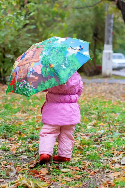小女孩在秋天走与孩子的水伞雨