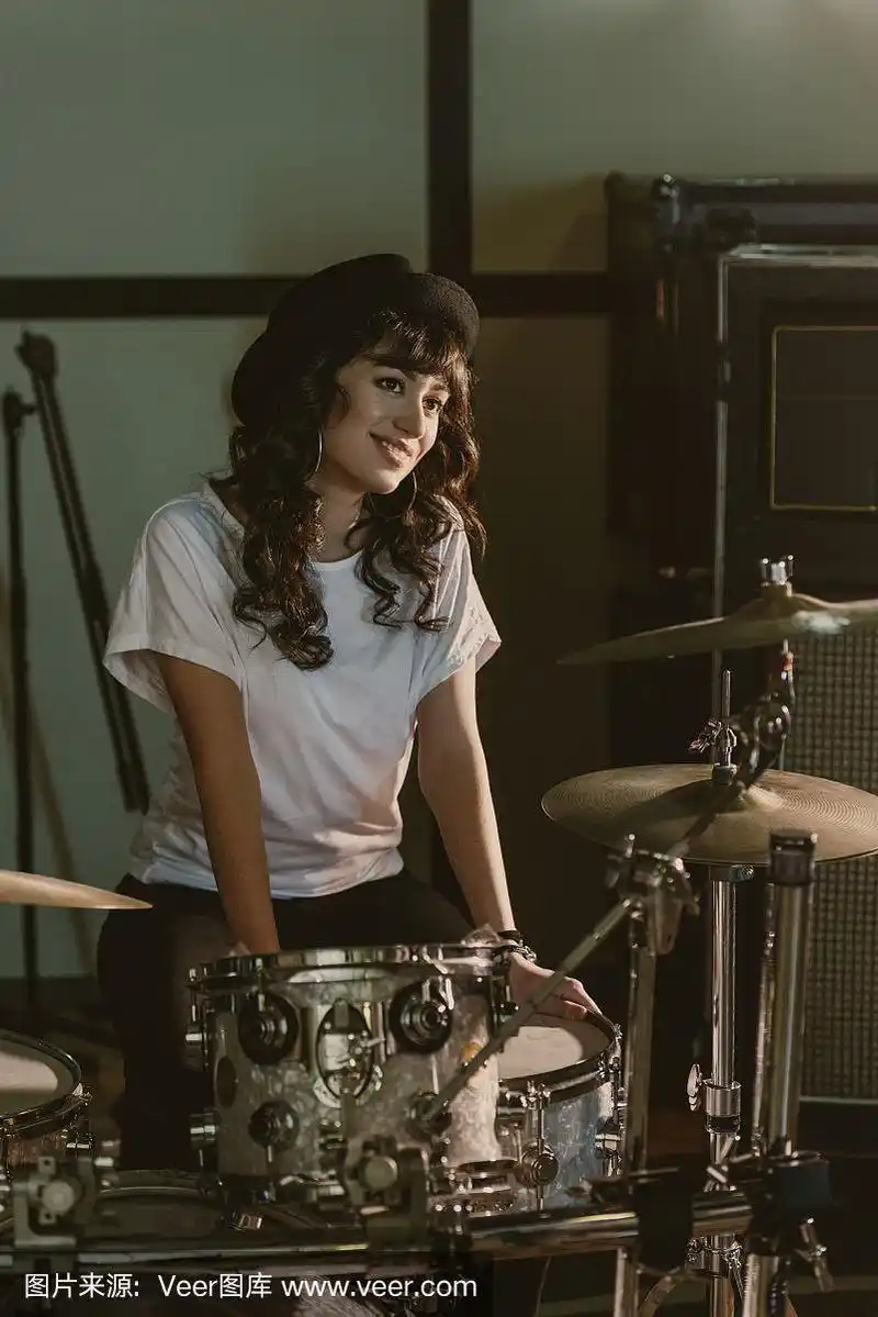 迷人的女鼓手坐在架子鼓
