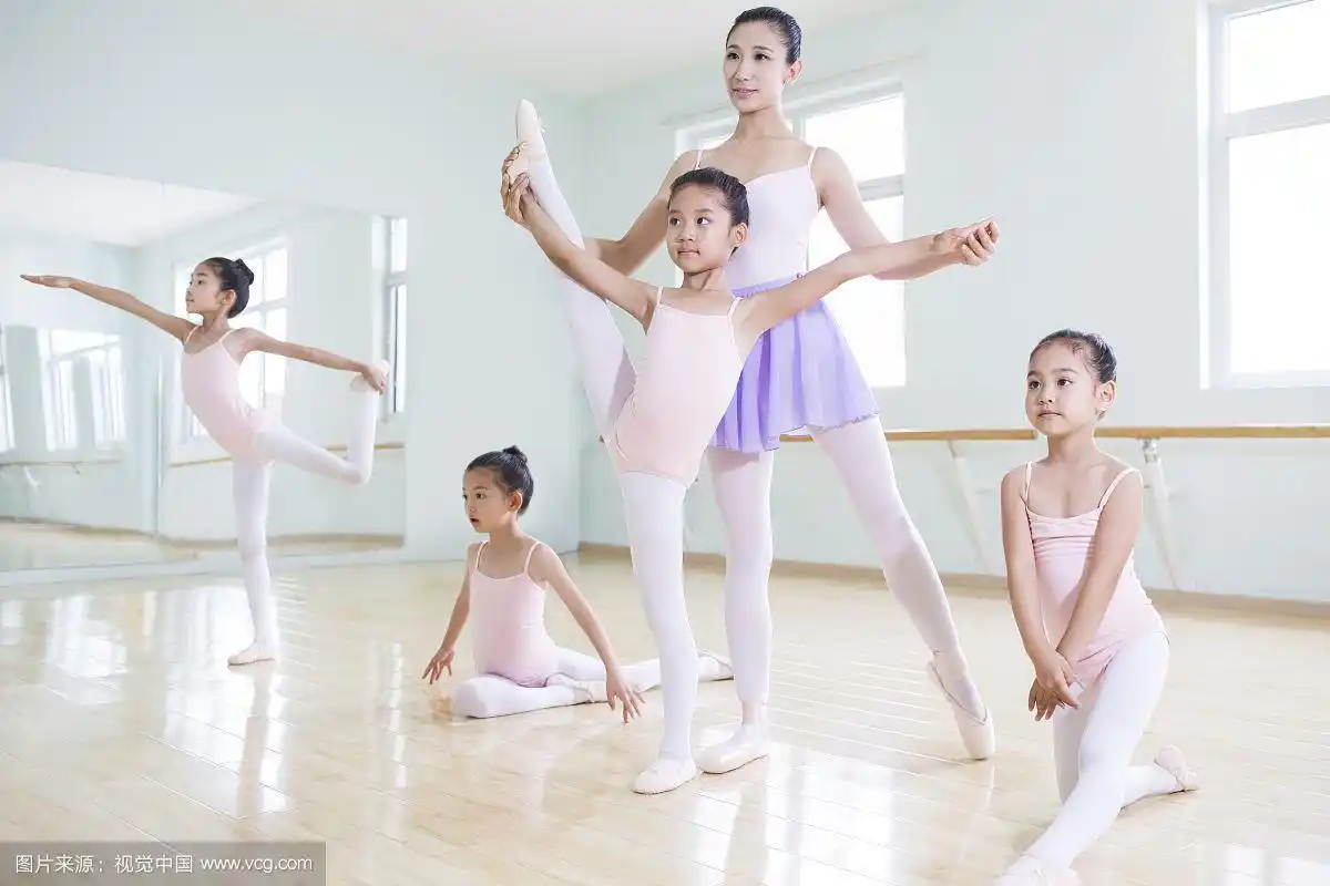 年轻舞蹈老师教小女孩们跳芭蕾