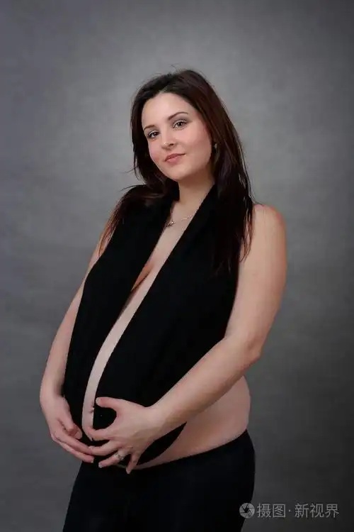 美丽怀孕的年轻女子温柔地捧着她的肚子