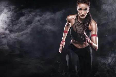 冒强一个强壮的运动员, 女子短跑运动员, 身穿黑色背景运动服, 健身和