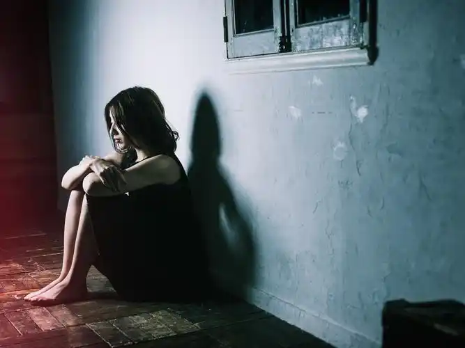 悲伤的女孩坐在地板上