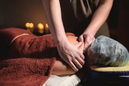 高级按摩.男理疗师按摩治疗师给女客户做上背部按摩照片