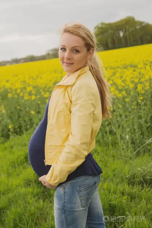 在油菜田的美丽孕妇