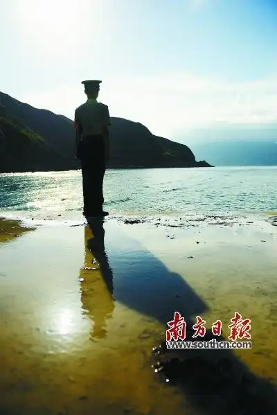 一位官兵在海边站岗,夕阳的余晖映衬坚毅的轮廓.王昌辉 摄