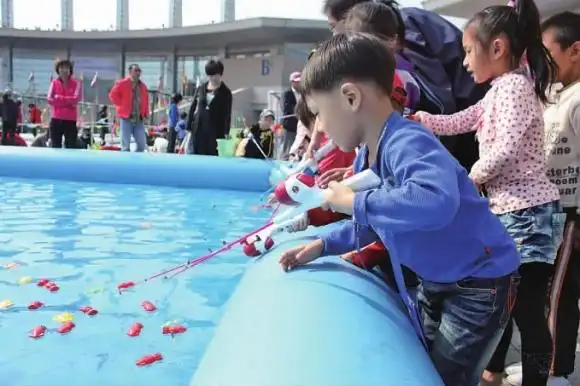 偌大的儿童钓鱼池周围,挤满了不少小垂钓者.