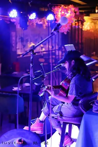 餐厅在夜光汇二层,室内餐区和露台连成一片,内外各设舞台,晚七时,驻唱