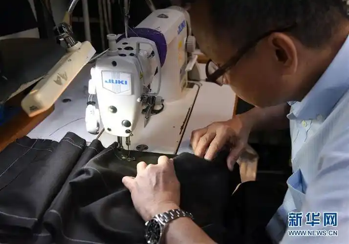 在香港天裁行店,一名老裁缝在缝纫布料(8月24日摄).