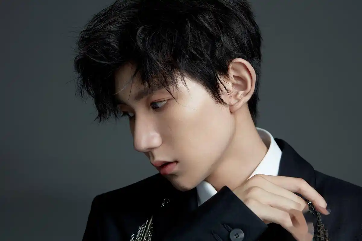 照片中王源随性坐在沙发一角直视镜头,眼神杀霸气十足