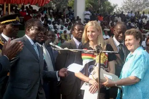 上图为2008年8月29日,津巴布韦总统(左二)为该国白人游泳运动员考文垂