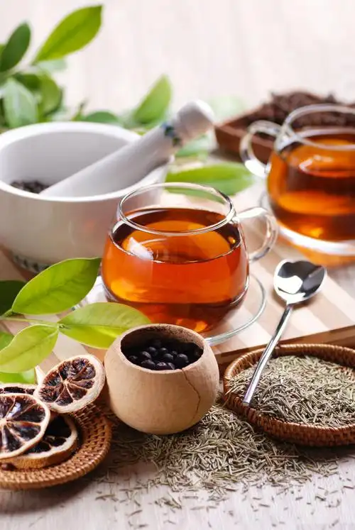 木质板板上杯里的茶和旁边的茶叶