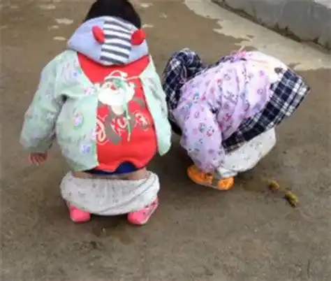 在一个淘气堡,小孩子们一起玩沙子里,一个三岁小朋友在里面,蹲着一边