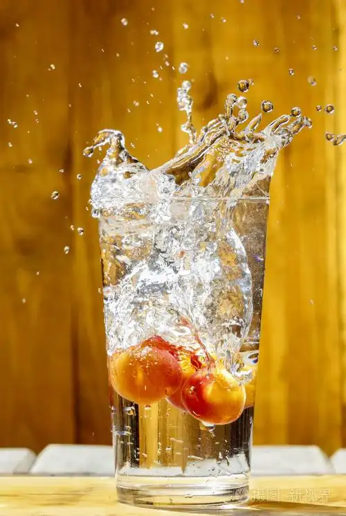 水在玻璃飞溅.在炎热的夏天一天杏饮料