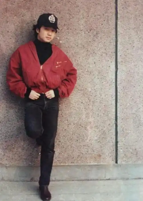 照片中徐峥头发茂密戴着鸭舌帽,一身红色夹克修身牛仔裤的装扮相当