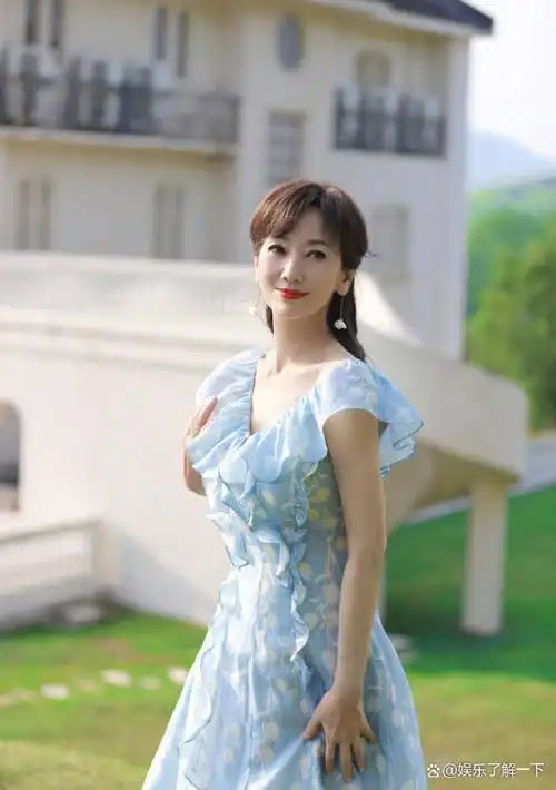 在照片中,赵雅芝身着一袭蓝色碎花裙,佩戴着白色花朵耳饰,笑容满面