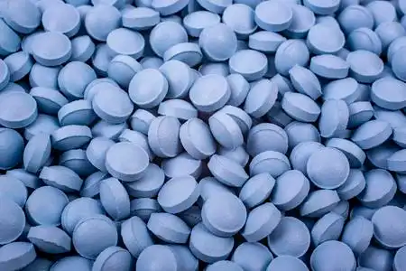 蓝色的药丸放在桌子上照片