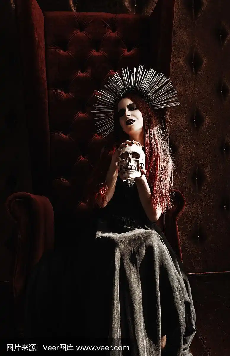 恐怖图片:迷人的年轻女巫拿着头骨