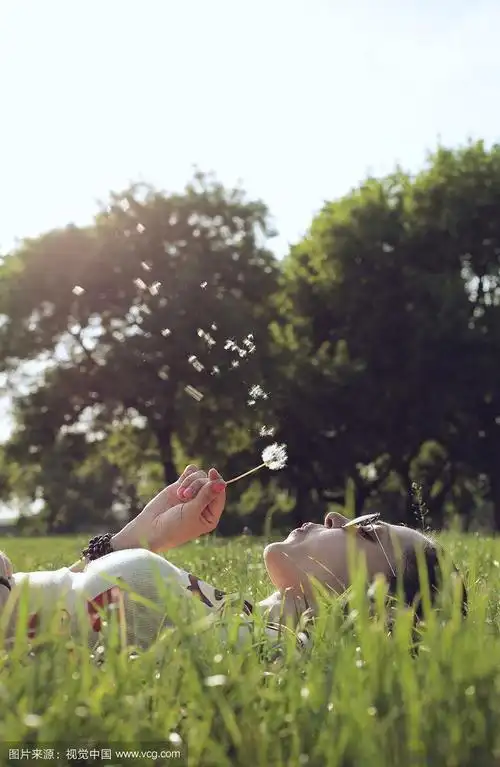 美丽的女孩吹蒲公英