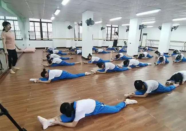 那大实验小学舞蹈班上,老师在教学生舞蹈基本功.