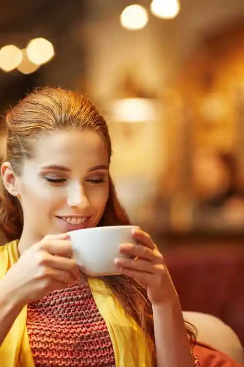 模糊背景前喝咖啡的美女