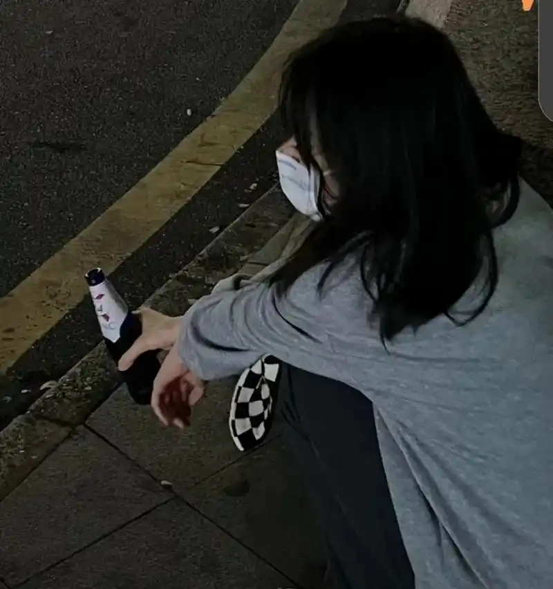 夜很静的大街上,路灯弱弱的灯光下,一个年轻漂亮的女子蹲在路边,她抱