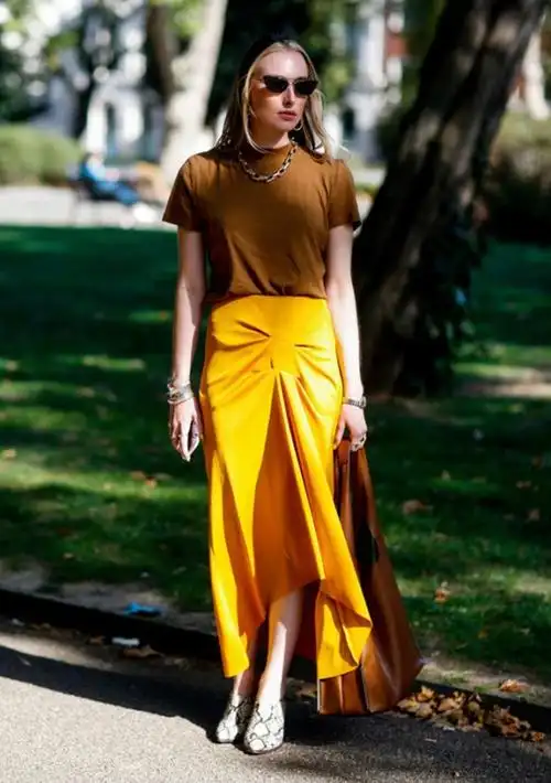 咖啡色的包包搭配与上衣搭衬,同时显露出这条金黄色的长裙带来的魅力