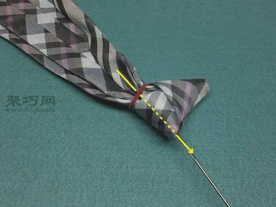 使其穿过领带的结.如果难以通过,请稍微松开橡皮筋.