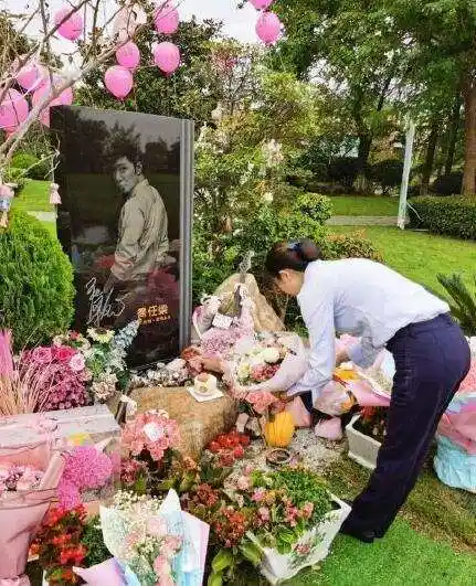 墓地周围摆满了粉色花束,墓碑也印有乔任梁生前的照片,能被粉丝一直