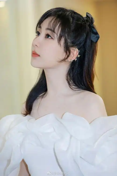 杨紫最新美照穿白色花瓣裙大秀一字肩卷发搭蝴蝶结发饰