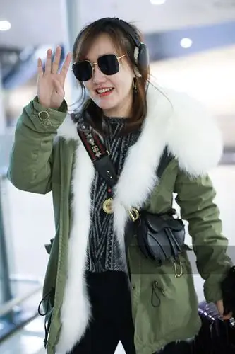 薛佳凝穿军绿色羽绒服配黑色长裤现身 对镜头挥手打招呼笑容超甜