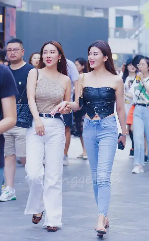 街拍美女闺蜜手挽手个性穿搭凸显多肉好身材