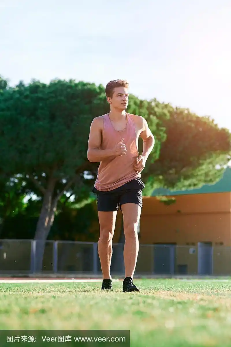 年轻的肌肉男在跑道上跑步