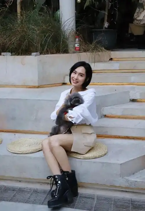 52岁朱茵近照身穿白色衬衫搭配米色短裙休闲时尚