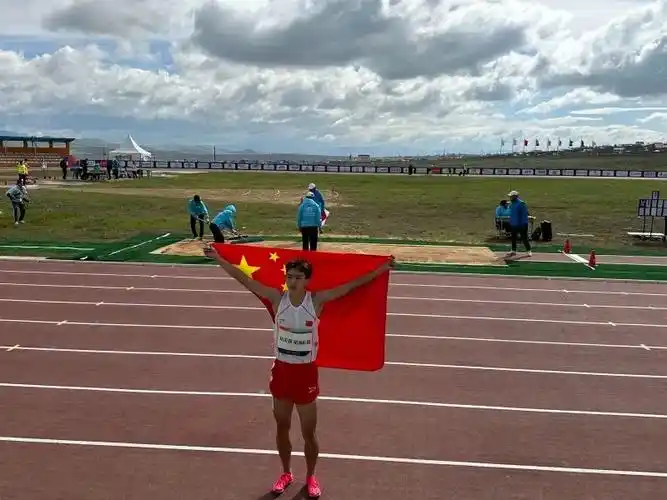 艾力西尔·吾买尔夺冠后身披国旗庆祝.