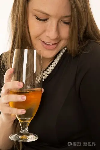 女人拿着酒杯,微笑着俯视