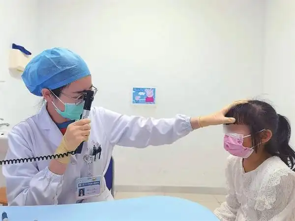 苏大附儿院眼科门诊医生使用检影镜为孩子检查视力.  记者 周函摄