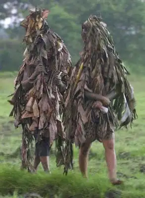 两名全身涂满泥巴,身穿用干树叶制成的衣服的信徒前往教堂参加本国